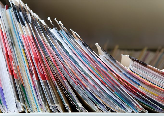Medical records A line of hardcopy files in the process of falling, ldomino-like.