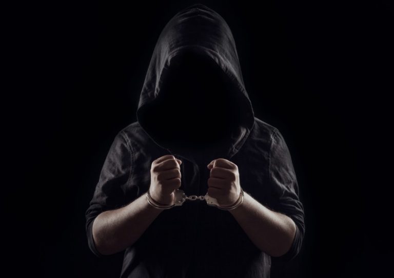 silhouette-of-handcuffed-male-in-hoodie-dangerous-criminal-punished-picture-id1183470642