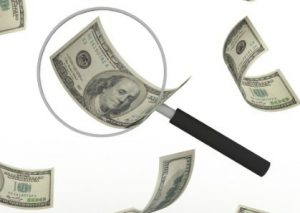Bills flotaing through the air, with a magnifying glass on one of them.