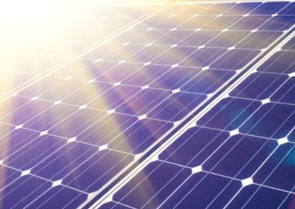 Green energy and sustainable development of solar energy Sunbeams hitting a solar array.