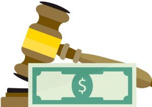 Gavel partly obscured by $ bill on the foreground.