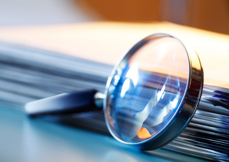 magnifying-glass-leaning-against-stack-of-papers-picture-id1208620496 magnifying-glass-leaning-against-stack-of-papers-picture-id1208620496