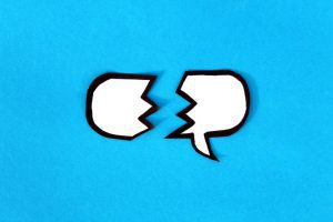 White word balloon, broken into two pieces, on a blue background.