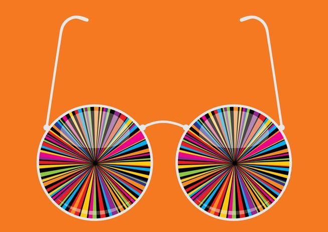 Psychedelic Twist Eyeglasses A pair of glasses with "psychedelic" design where lenses should be, on a bright orange background.