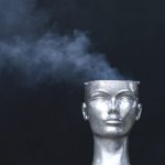 Metallic renditon if a guy's head with the top sheared off and smoke coming out of it.