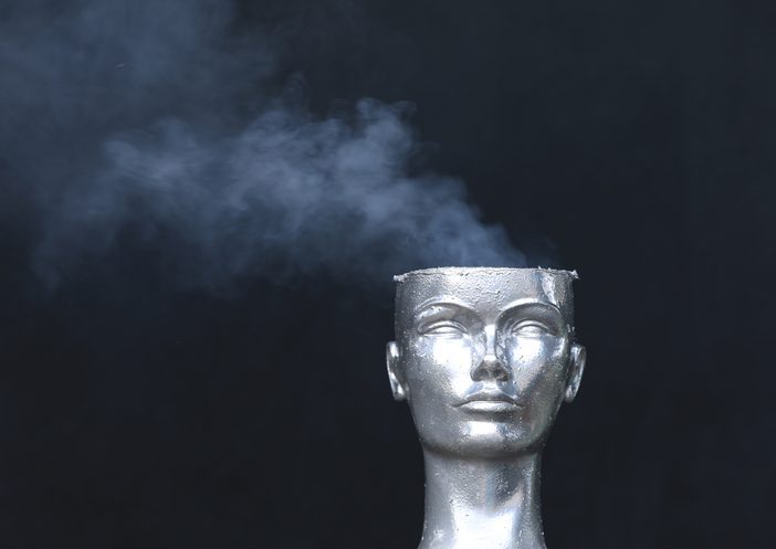 Metallic renditon if a guy's head with the top sheared off and smoke coming out of it.