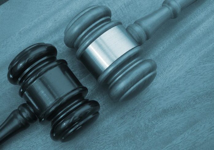 Different court decisions concept Closeup of two gavels, posed as if they are facing off.