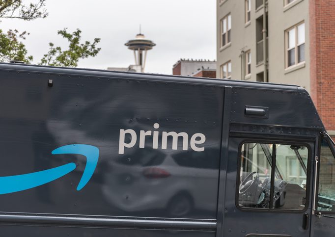 Seattle Prime Amazon prime truck with Seattle space needle in the distant background.