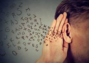 Picture of a guy with his ear cocked, hand against his hear to hear better, and into his ear appear to be flowing a tide of letter and symbols.