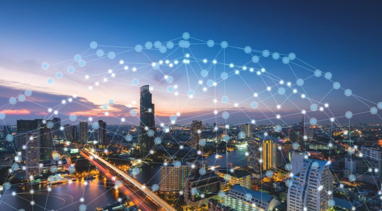 Wireless network technology smart city A modern cityscape from low altitude, with sky and mountains in the background, and imposed virtual lines connecting everything.