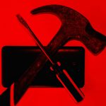 Ominous looking objects in silhouette - screw driver and hammer crossed in front of a cellphone.
