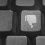 Close up of a few keys on a keyboard. One of them has a "thumbs down" icon on it.