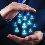 Constructed Illustration showing, in front view, a guy with suit holding within his cupped hands icon representations of human figures, presumptively "employees."