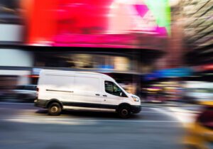 Delivery van in a city, with a blurred background suggesting it might be speeding.