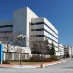 Color photo of a modern white building that looks like it's probably a hospital.