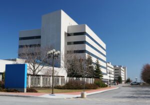 Color photo of a modern white building that looks like it's probably a hospital.