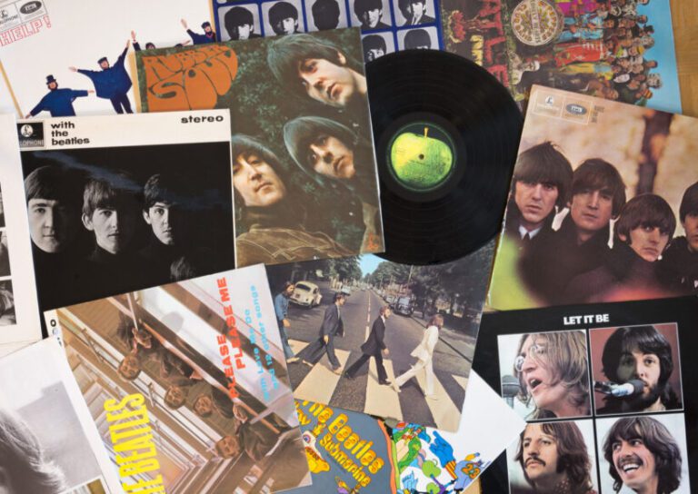 Gothenburg, Sweden - March 2, 2014: The Beatles musical pop/rock band from England. Vinyl record covers and one black vinyl record with a green apple on the label. Originals from the sixties, old and well used