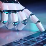 Robot hand typing on keyboard